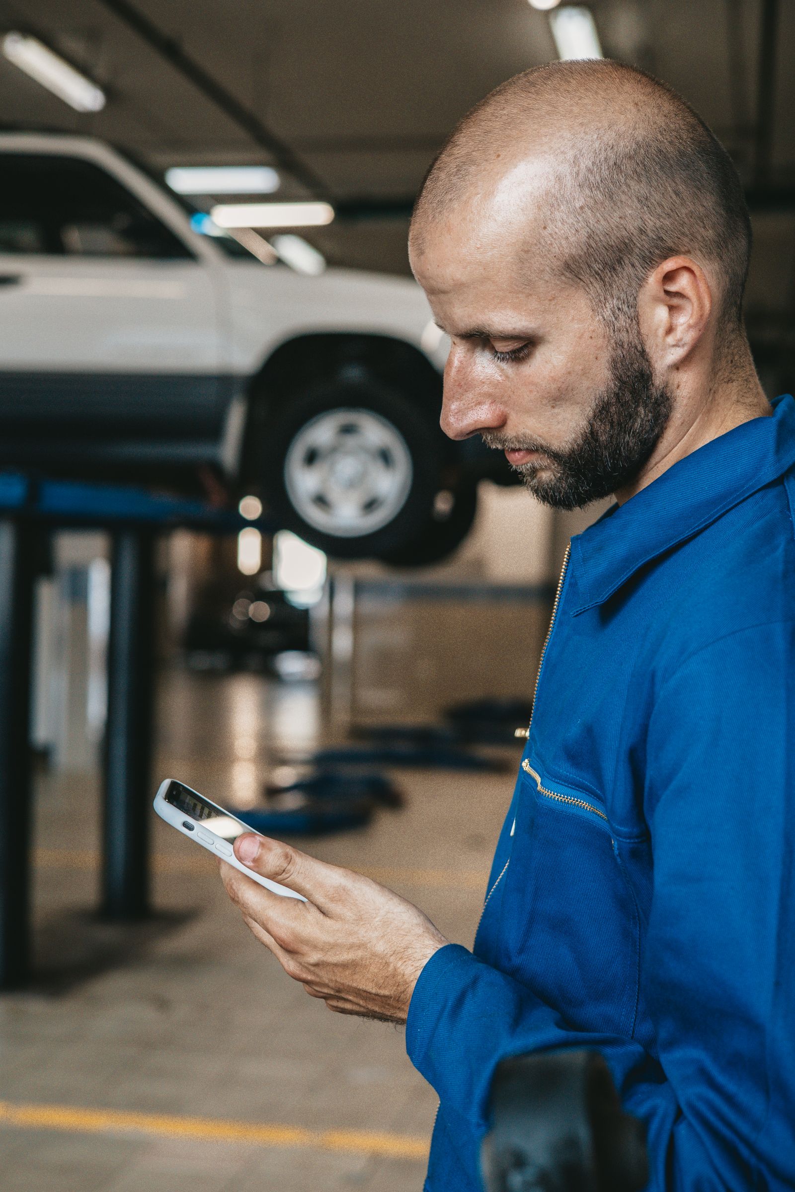 Mecânico trabalhando em veículo dentro de oficina, representando produtividade, comissão e controle financeiro da equipe